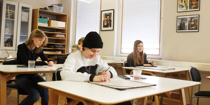 Fyra elever sitter i klassrummet och skriver